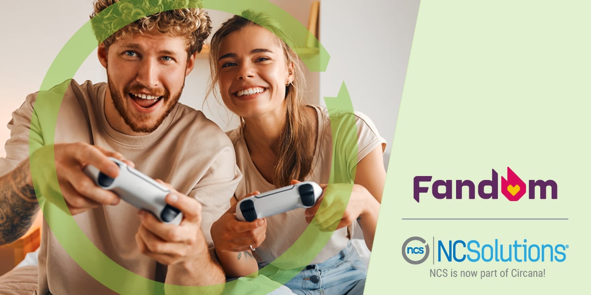 Young couple playing video games while sitting on the bed with a golden retriever at their side. Fandom and NCSolutions logos listed together on the right bottom corner.